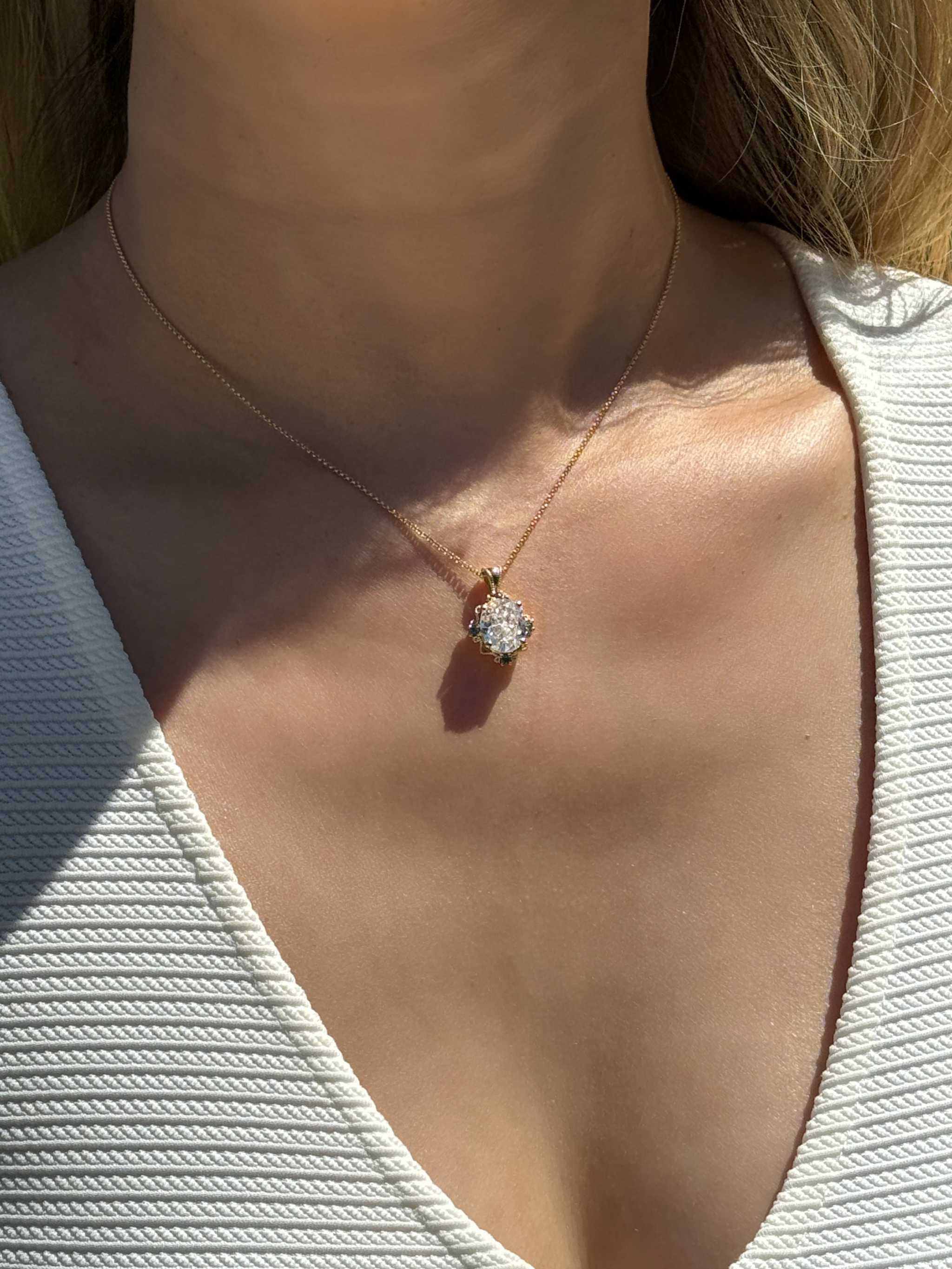 14K yellow gold pendant with 4.2 CT oval moissanite and 4 natural alexandrite stones in a vintage inspired mirror style worn on a delicate chain