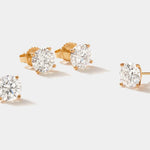Set of lab grown diamond stud earrings in 14k gold four-prong martini setting with round FG VS2 diamonds totaling 3 carats.