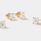 Set of lab grown diamond stud earrings in 14k gold four-prong martini setting with round FG VS2 diamonds totaling 3 carats.