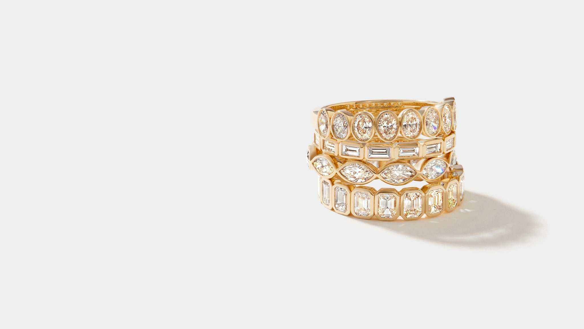 stacked bezel set eternity rings with various diamond shapes in 14k gold