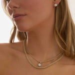 Woman wearing 3 carat lab grown diamond stud earrings in 14k gold four-prong setting