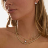 Woman wearing 3 carat lab grown diamond stud earrings in 14k gold four-prong setting