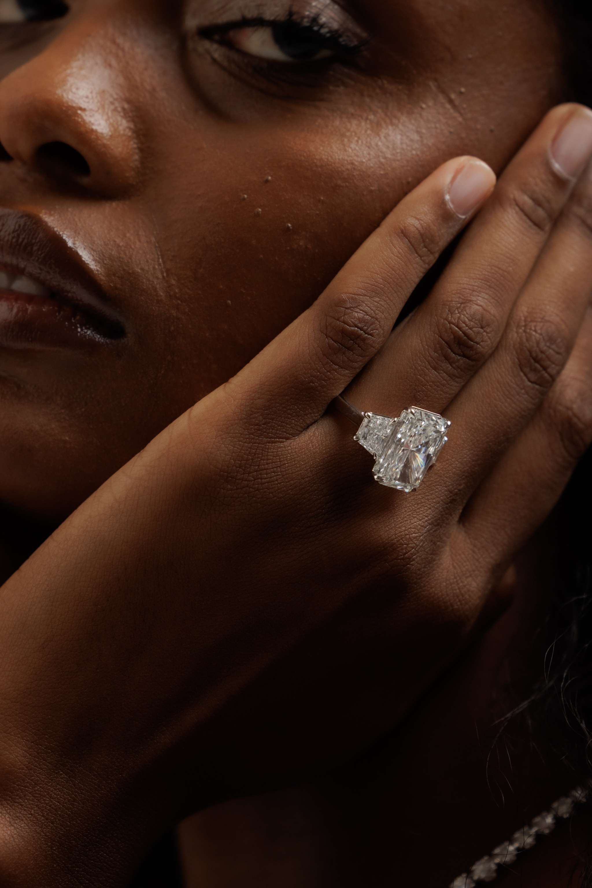 14K white gold radiant-cut three-stone engagement ring with 10.05 carat center diamond and trapezoid side stones