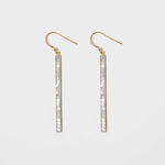 Miladi large gold vermeil earrings with long geometric bars inlaid with raw uncut diamonds and white resin.