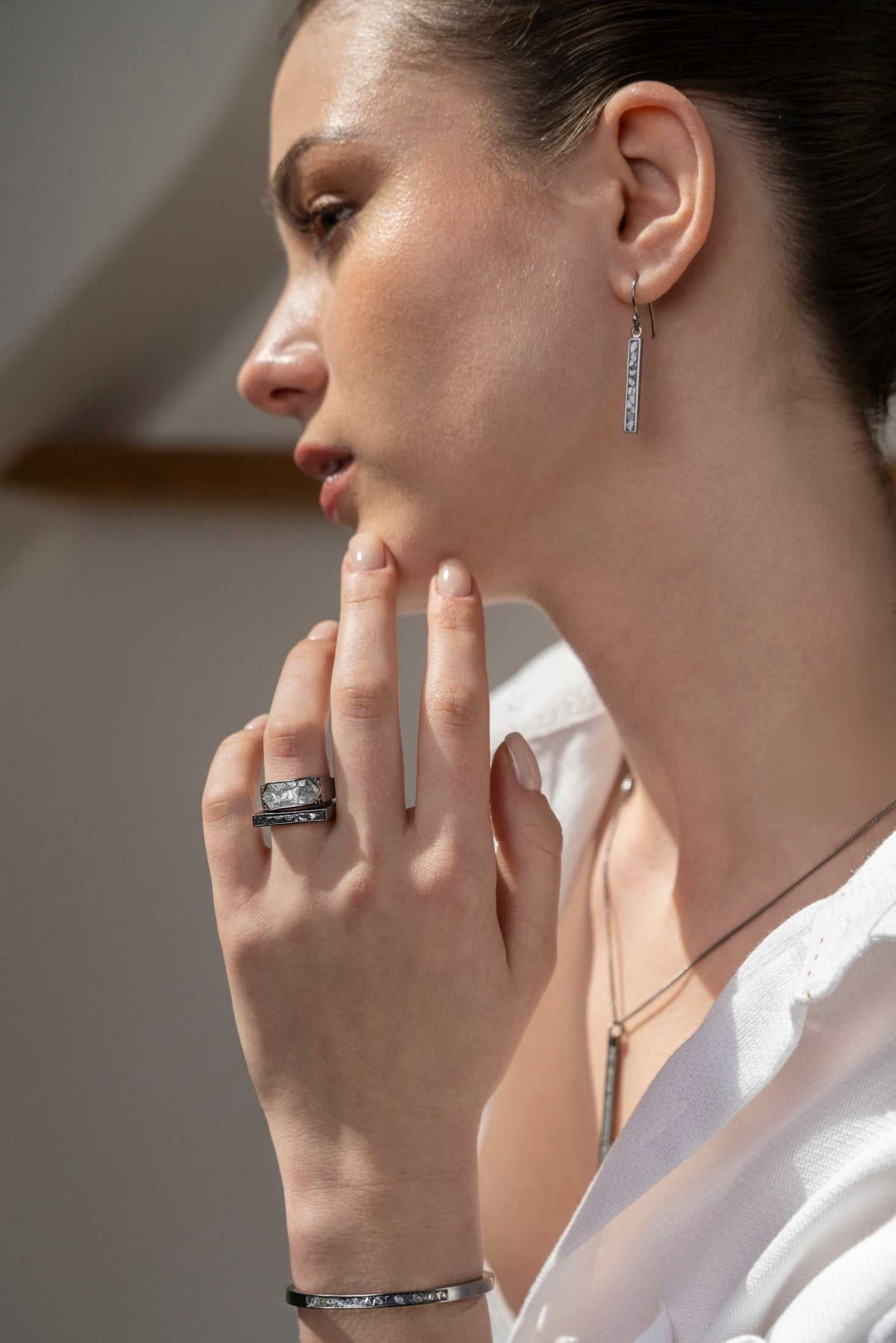 Miladi Small Oxidized Silver Earrings with raw diamond accents on a woman wearing matching oxidized silver rings and necklace