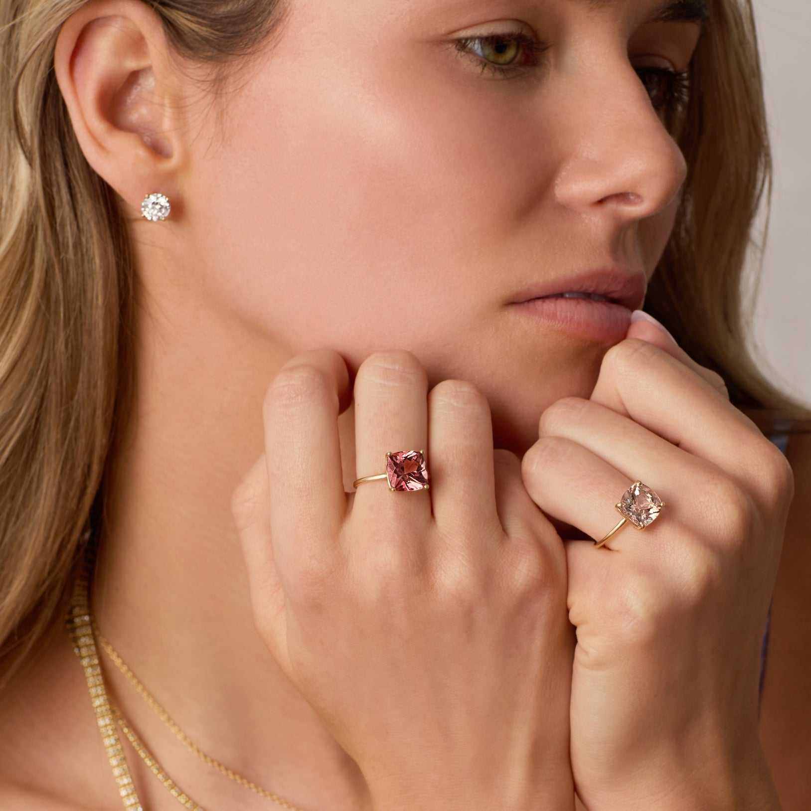 Close-up of a woman wearing a 14k gold Connecticut Coast Morganite Ring with a cushion-cut peach morganite stone on her finger.