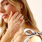 woman wearing lab grown diamond stud earrings with gold settings and a gold necklace with a bow on her shoulder
