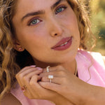 Close-up of woman wearing Nantucket Red pink tourmaline cushion-cut stud earrings with 14k yellow gold mounts.