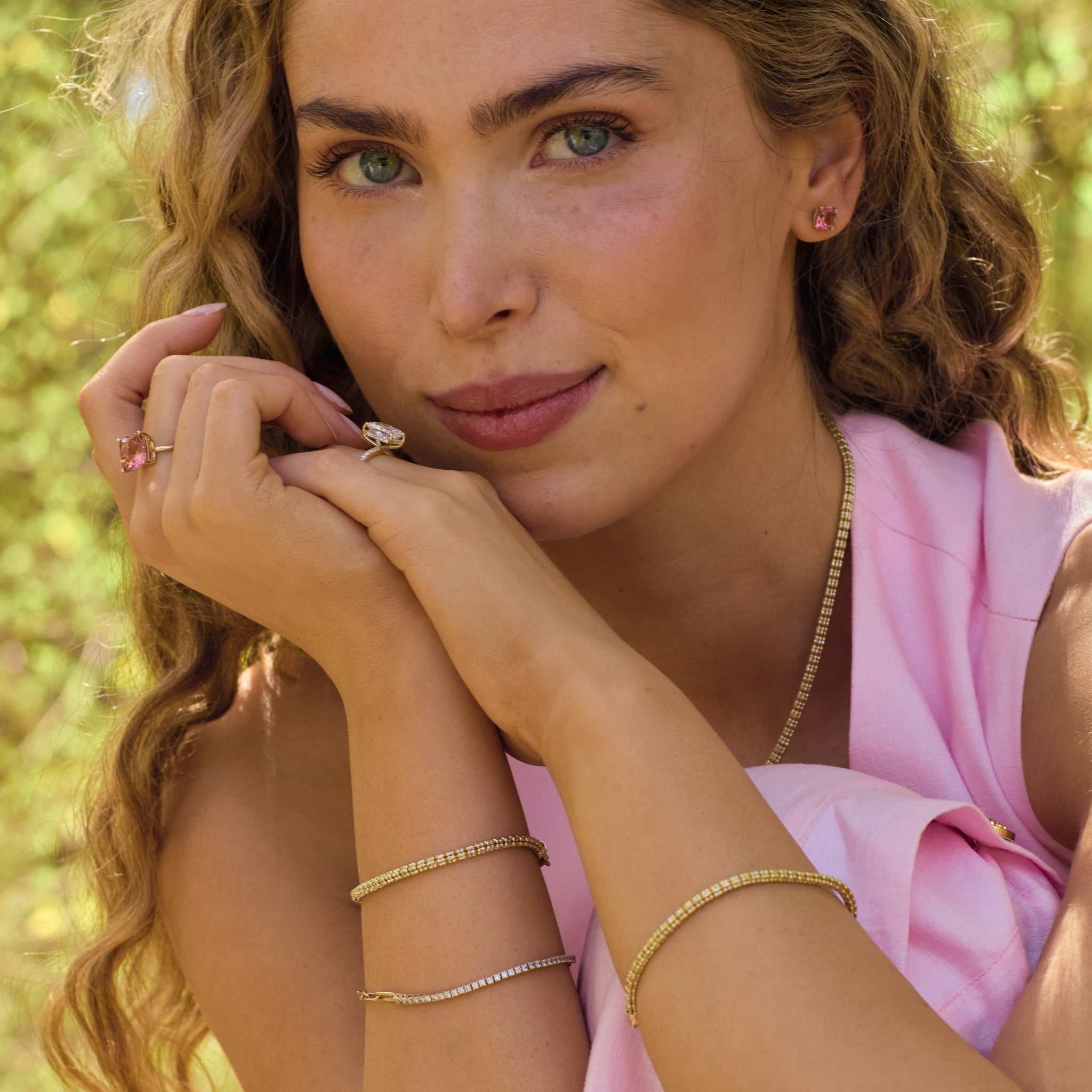 Woman wearing Tidal Tennis 14K Gold Bracelet and rings with natural outdoor background