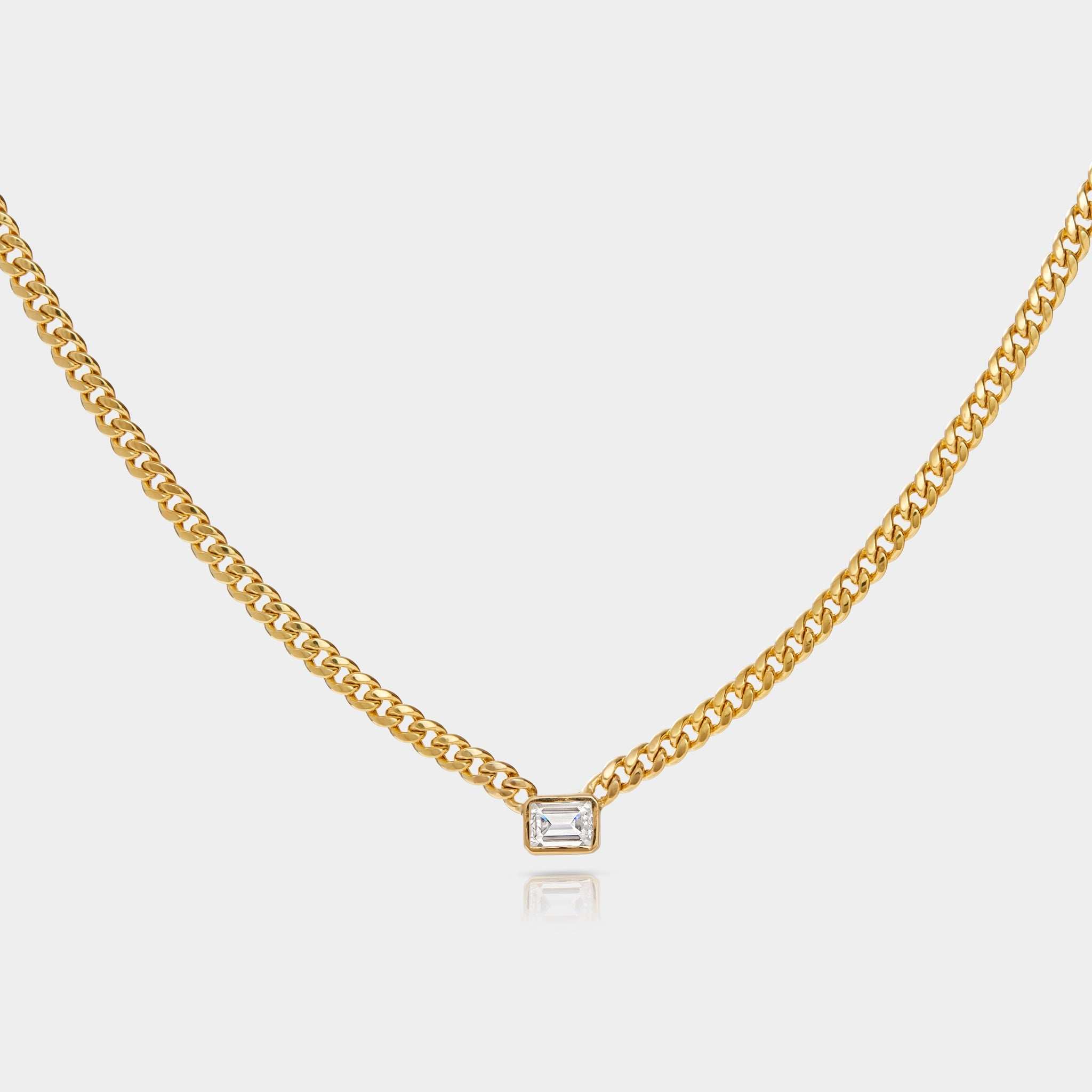 Emerald cut diamond bezel-set on yellow gold Cuban chain necklace